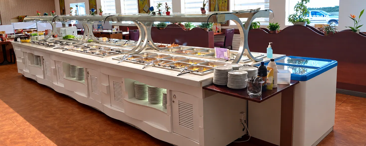 Le long buffet blanc du Sushi d'or sous les lampions jaunes, avec ses vitrines en inox.