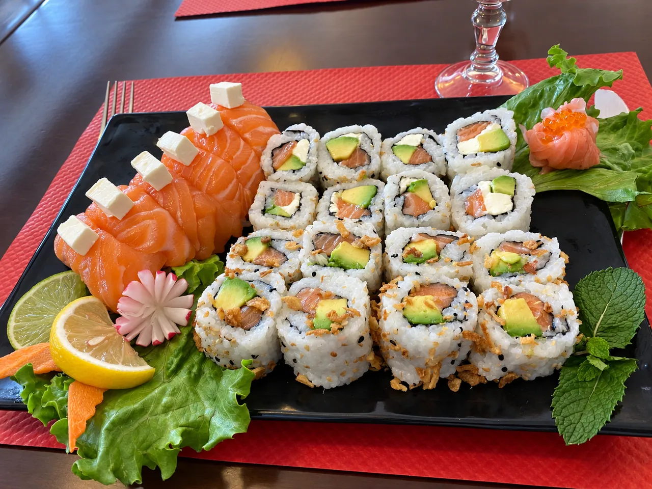 Plateau de californias et sashimis de saumon sur set rouge.